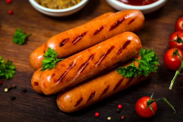 grilled smoked sausages on wooden background selective focus