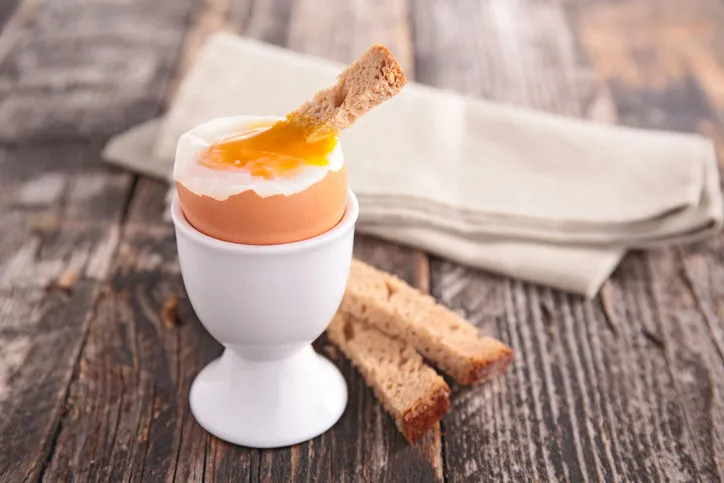 soft boiled egg being served with slices of bread