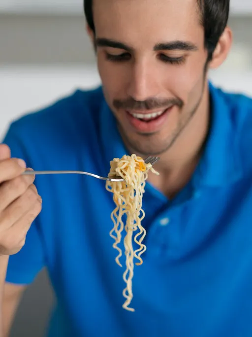 latin man eating pasta