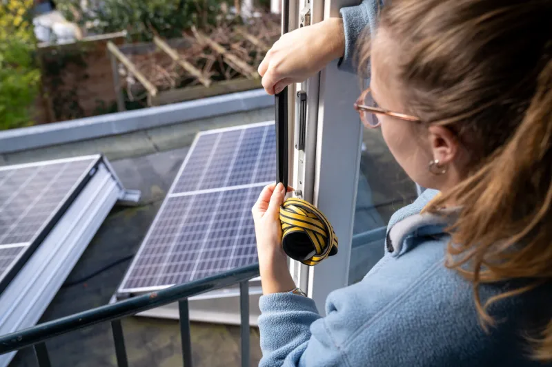 young woman makes her home energy efficient with the help of draft strip and solar panels to save the planet
