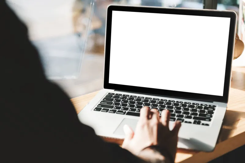 young man working on his laptop with blank copy space screen for your advertising text message in office, back view of business man hands busy using laptop at office desk