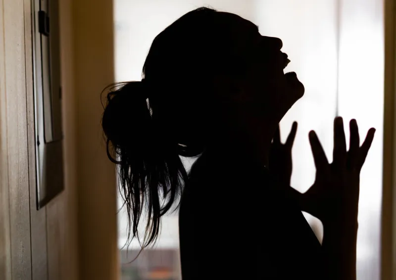 silhoutte of a woman with her mouth opened yelling in panic and frustration mental illness
