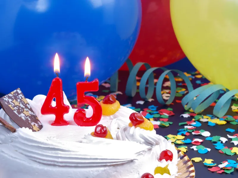 45th anniversary   birthday cake in a party background with balloons and party strings