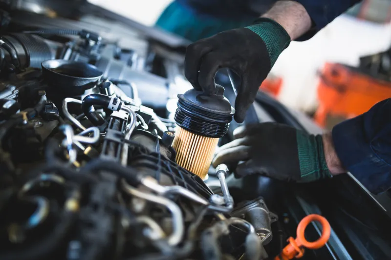 close up hands of unrecognizable mechanic doing car service and maintenance oil and fuel filter changing
