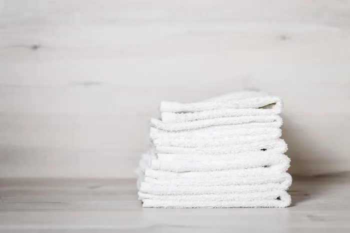 pile de serviettes spa sur une table en bois blanc