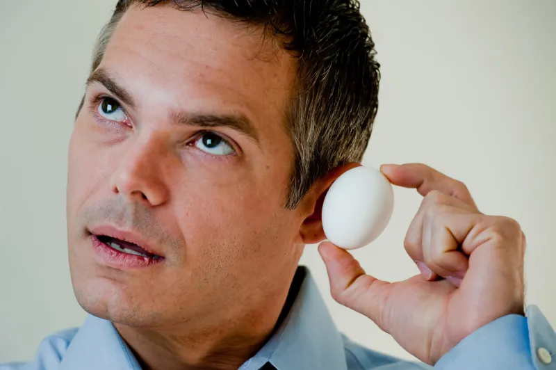 man wondering what's in the egg