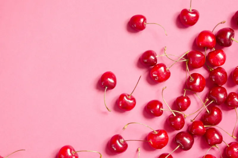 flat lay of cherries on a pink background top view - image