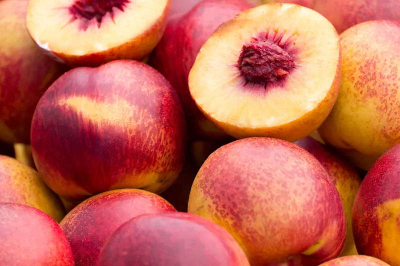 view of a pile of fresh and juicy peaches in a farmer's market