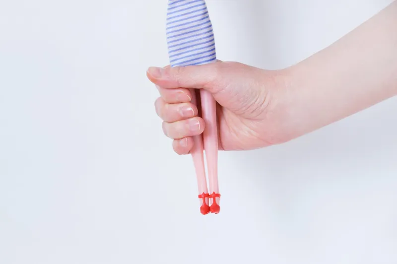 toy doll in the hands of a caucasian girl close-up on a white background