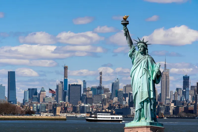 the statue of liberty over the scene of new york cityscape river side which location is lower manhattan,architecture and building with tourist concept