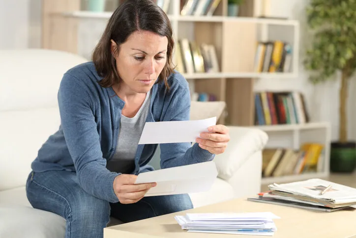 serious adult woman looking receipts at home