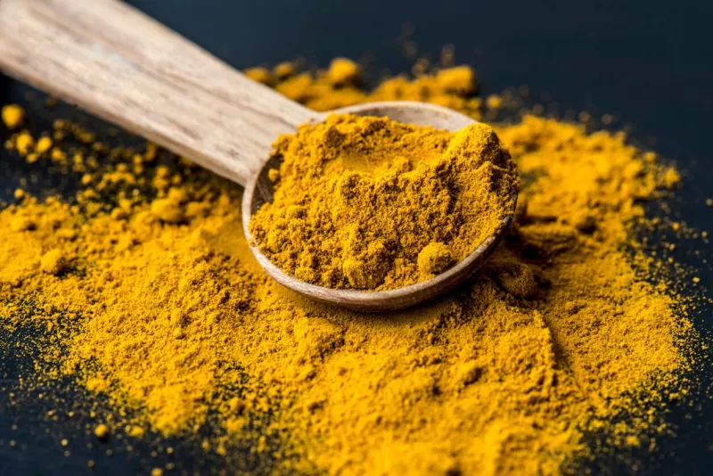 closeup of tumeric powder spice on a spoon