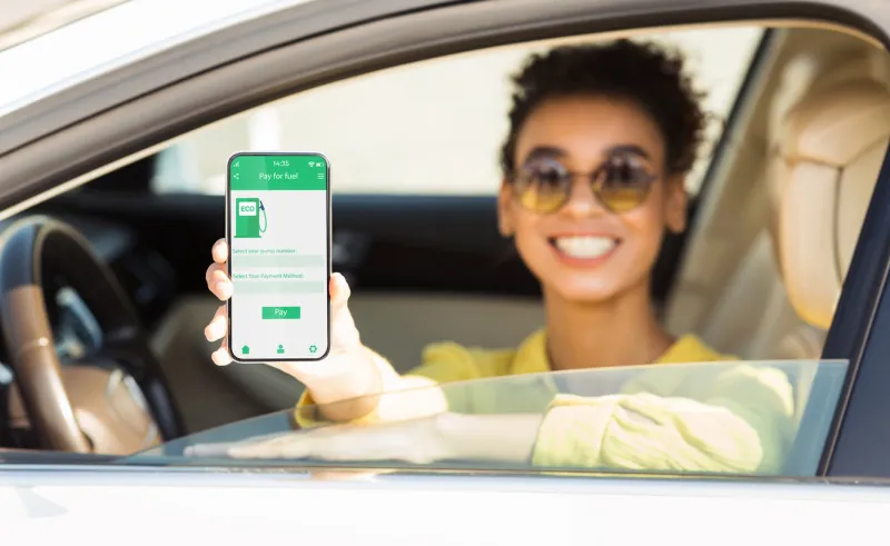 happy black woman showing smartphone with mobile app to purchase eco fuel from her car window, panorama african american lady choosing ecological petrol, making online payment, collage