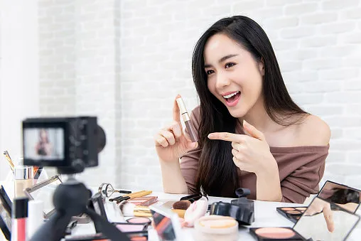 young beautiful asian woman professional beauty vlogger or blogger recording makeup tutorial to share on social media