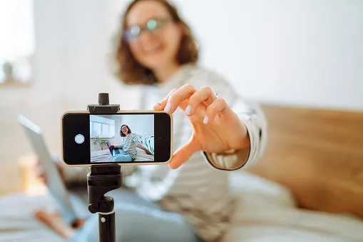 video blog young woman looking into the camera and telling her story while leading a video blog vlogger makes online streaming using phone social media, instagram, stay home and quarantine