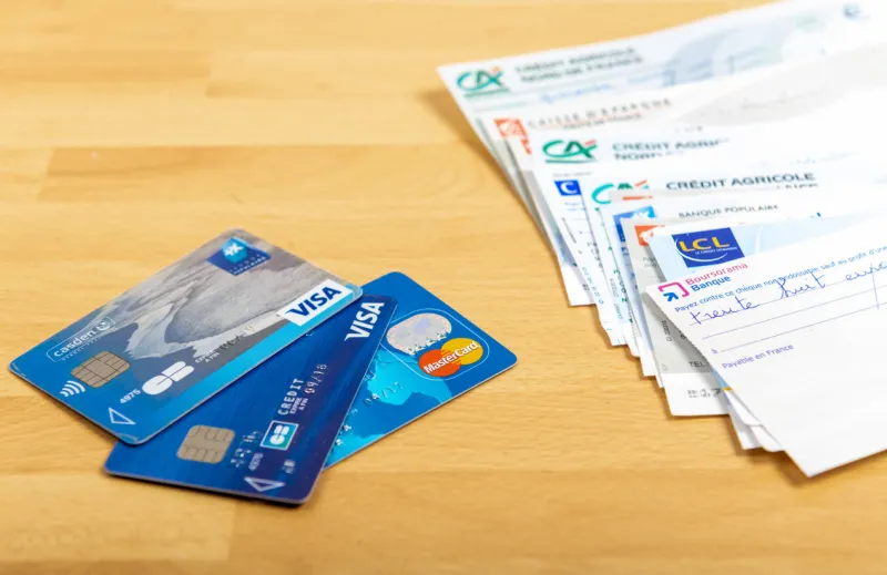 paris, france - november 18, 2019   checks of different french banks and credit cards set on a wooden desk france is the european country where checks are most used