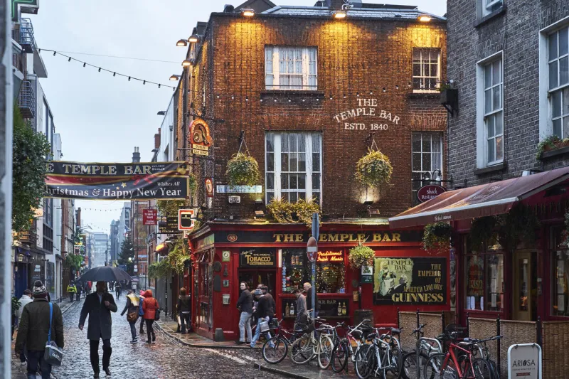 dublin, ireland - january 5, 2016  pedestrians walking around street in temple bar during rainy evening the area is the heart of tourism in the city