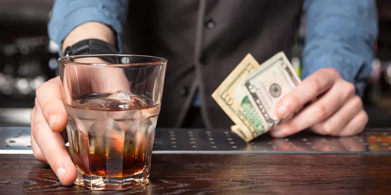 barman giving whiskey glass with booze - concept image