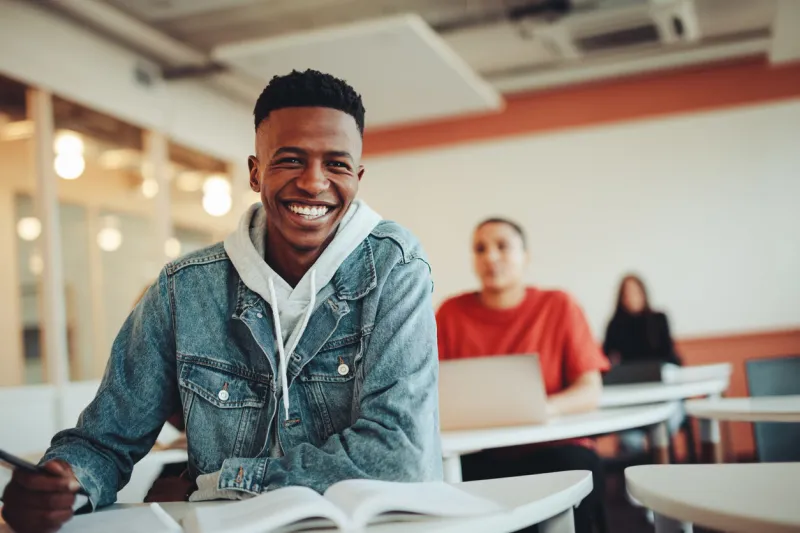 african student sitting in classroom male student smiling during the lecture in high school classroom