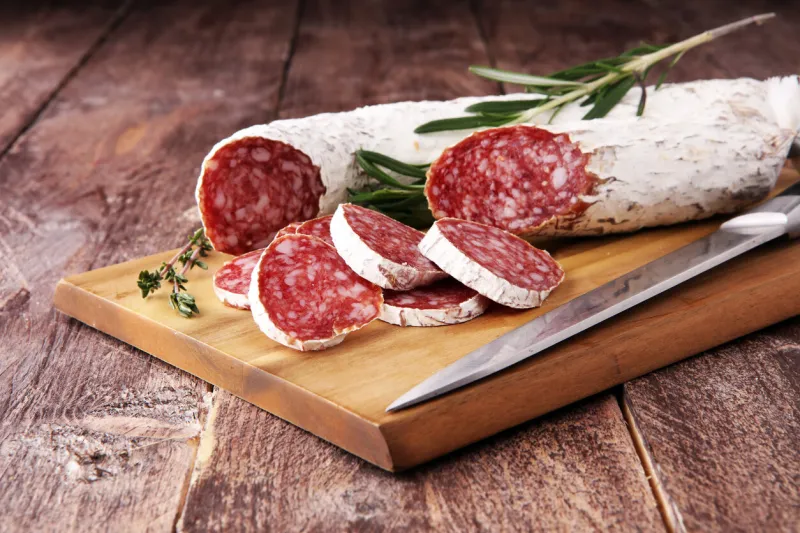 marble cutting board with sliced salami on it