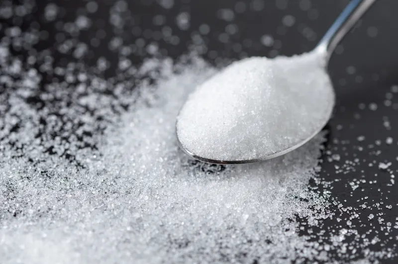 close-up of spoon with sugar on the black table