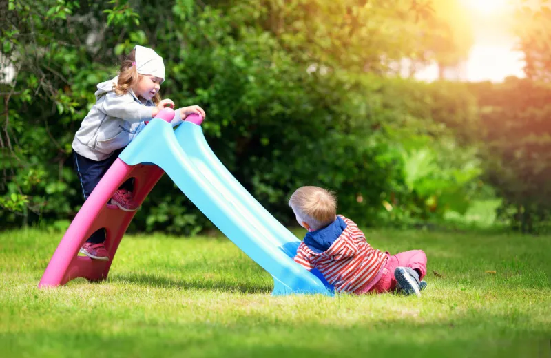boy and boy playing on the backyard on sliding