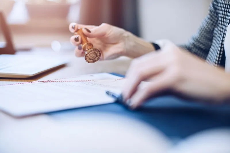 woman notary public or judge stamping and authorizing document in law office