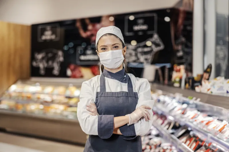 portrait of a female butcher at supermarket during corona virus