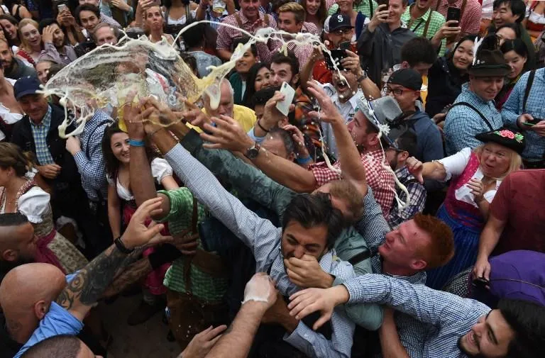 people spill a glass of beer during the 185th oktoberfest, munich's annual beer festival, on september 22, 2018 in munich, southern germanythe world's largest beer festival is held from september 22 until october 7, 2018   afp photo   christof stache