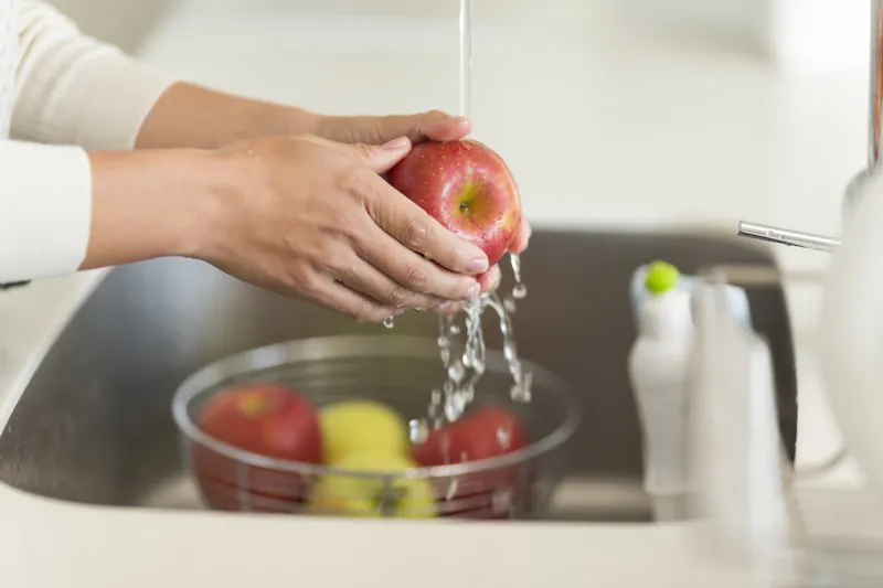housewife washing apple with water