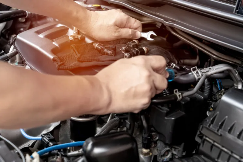 technician use wrench and screwdriver removing the gasoline injector part on engine maintenance concept check and service