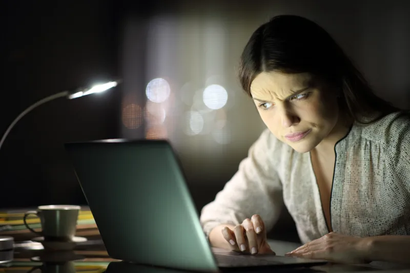 suspicious woman checking laptop content in the night
