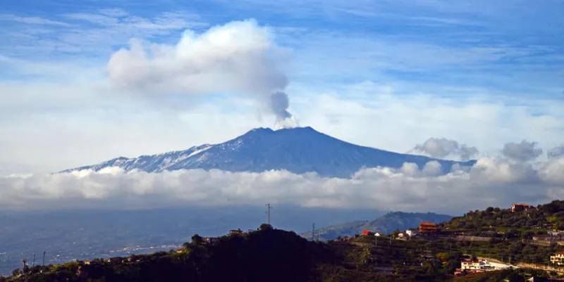 smoke rises over the city of taormina during an eruption of the mount etna, one of the most active volcanoes in the world, near catania, on december 4, 2015   afp photo   giovanni isolino