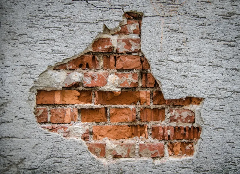 conceptual image of a rustic wall with hole in the plaster