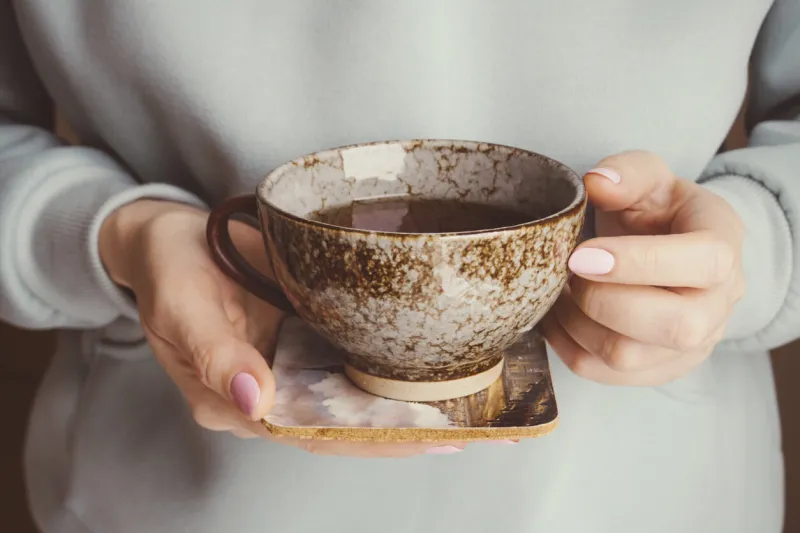 woman holds cup of tea