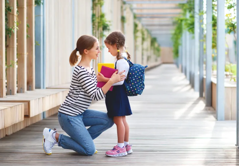 first day at school mother leads a little child school girl in first grade