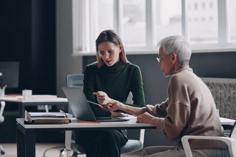 confident financial advisor discussing options with senior woman in the office