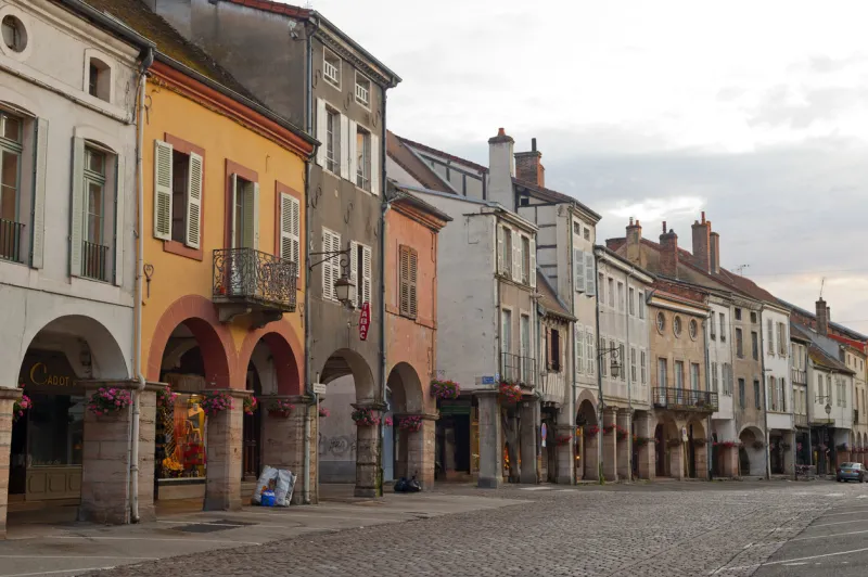 louhans, france - july, 5 2009  the main street with portico of the historic town in burgundy, at evening