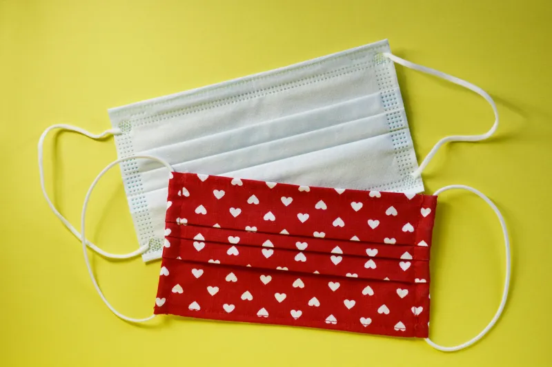 two face masks on yellow background