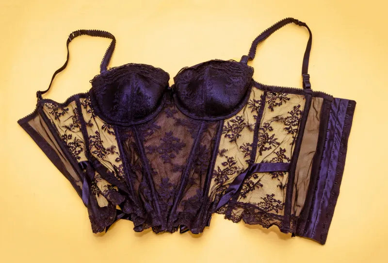 sexy black lace corset fashion undergarment isolated on yellow background