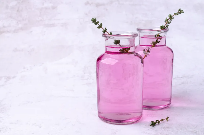 pink drink with thyme in a glass on a light background selective focus