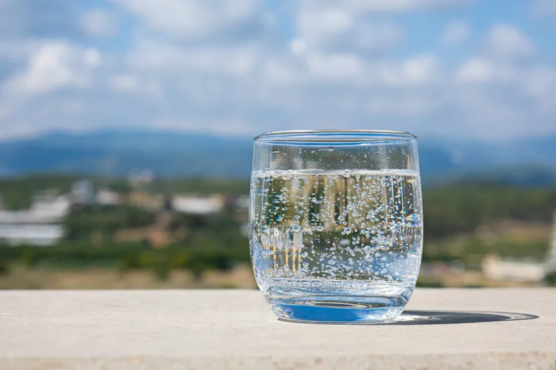 sparkling water glass on a stone parapet with a mountain view cool glass of mineral water mountain mineral water