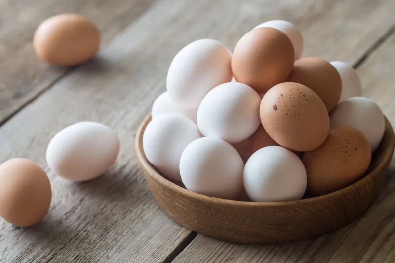 wooden bowl of raw chicken eggs