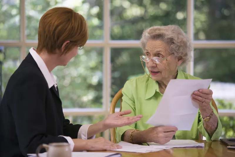 mature woman talking to financial planner at home