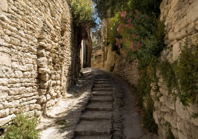 steep alley with medieval houses in gordes provence, france