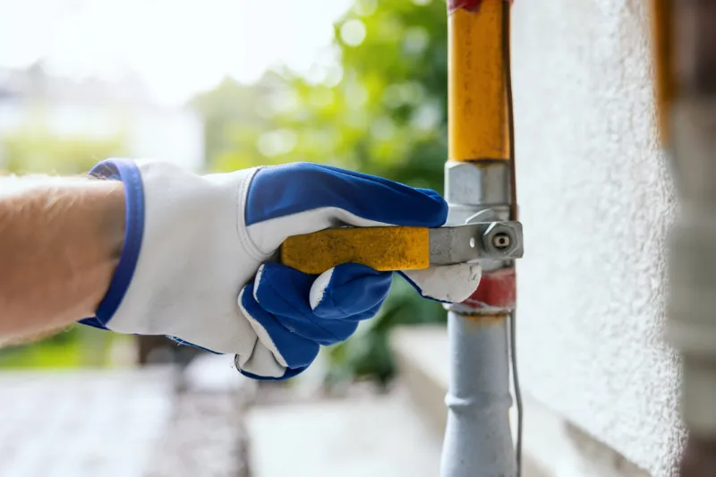 hand closes the household gas pipe valve