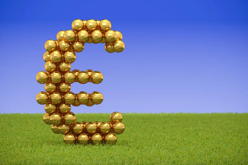 3d render  golden soccer balls forming a euro sign on grass and blue sky background big business   corruption in sports, football, soccer copy space to the right