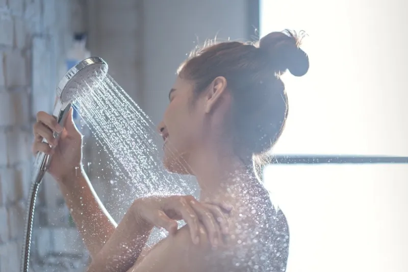 asian woman is taking a shower and rubbing her shoulders