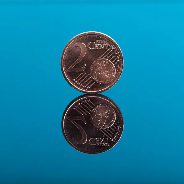 2 cents, euro money coin on blue colored background with reflection on mirror surface, studio shot
