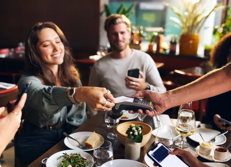 woman paying with card in restaurant